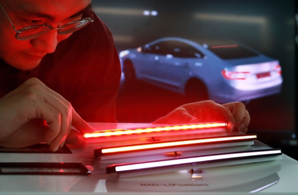 LG이노텍 직원이 차량용 초슬림 라인조명모듈 ‘넥슬라이드-L’을 살펴보고 있다. 이 제품은 광(光)선폭 3mm의 슬림 라인에 고른 빛을 내 자동차 디자인 완성도를 높일 수 있다. 또한 조명 용도에 따라 컬러와 모양, 밝기를 맞춤 제작할 수 있다. [사진=LG이노텍 제공]