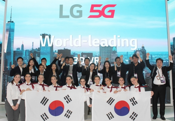 MWC LG 5G부스에서 LG유플러스 및 LG전자 직원들과 부스 운영직원들이 3.1절을 기념해 태극기를 들고 만세를 외치고 있는 모습. [사진출처=LG유플러스]