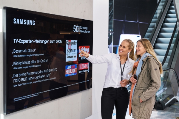 독일 프랑크푸르트 시내에 위치한 삼성 쇼케이스 매장에서 판매 직원이 고객에게 영상·음향기기 전문 매체들로부터 호평받은 QLED TV를 소개하고 있다. [사진=삼성전자 제공]