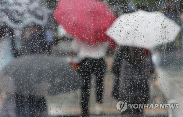 서울 광화문역 출구 유리 너머로 시민들이 우산을 들고 역사를 나서고 있다. [사진=연합뉴스 자료사진]
