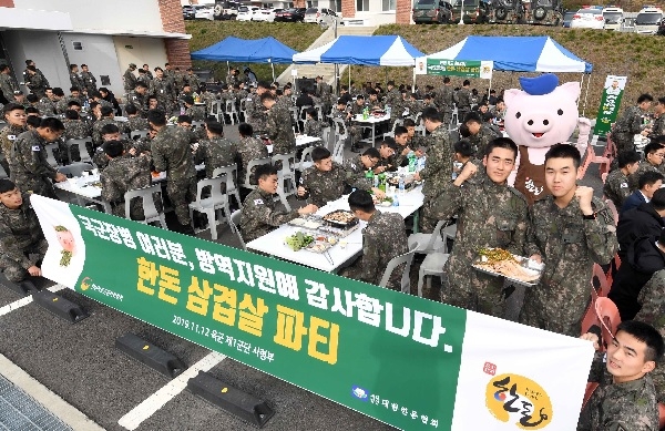 12일 육군 제1군단사령부에서 열린 한돈 삼겹살 회식에서 병사들이 삼겹살을 먹으며 즐거워하고 있다. [사진=한돈자조금]