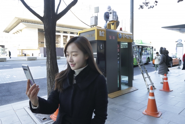 서울 광화문에 교체 설치된 측정소 앞에서 KT 홍보모델이 에어맵코리아를 홍보하고 있다. [사진=KT 제공]