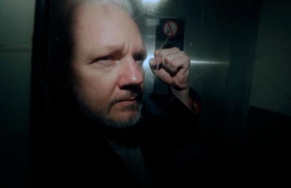 위키리크스 설립자 줄리언 어산지가 런던 법정에서 이송되던 중 주먹을 높이 들고 있다. [AP=연합뉴스]