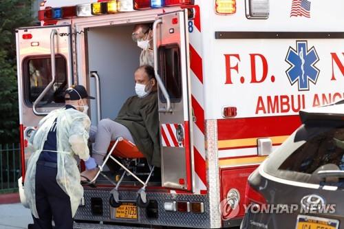 미 뉴욕소방서 응급의료전문가들이 보호장비를 착용한 채 코로나19 환자를 앰뷸런스에 태우고 있다. [로이터=연합뉴스 자료사진]