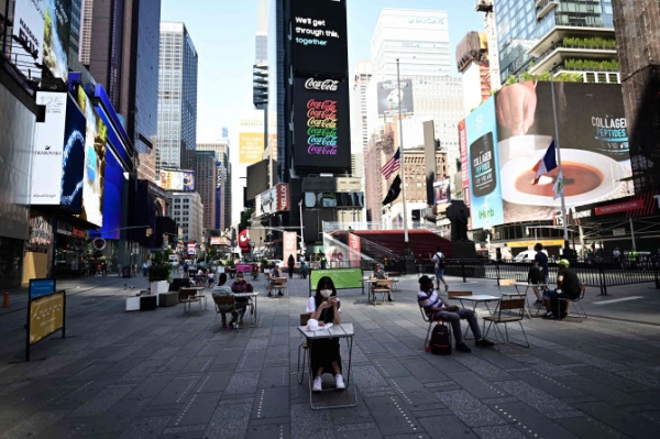 맨해튼 중심가 타임스퀘어에서 사람들이 ‘사회적 거리두기’를 지키며 탁자에 앉아 있다. (사진=연합뉴스)