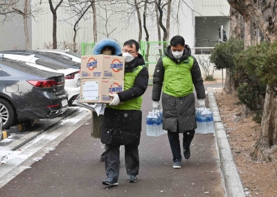 코오롱인더스트리 직원들이 강서구 홀몸 어르신 가정에 생필품을 지원하기 위해 물품을 운반하고 있다. [사진=코오롱그룹 제공]