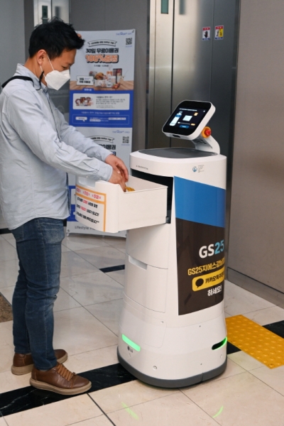 서울 강남구 역삼동에 위치한 GS타워에서 ‘LG 클로이 서브봇(LG CLOi ServeBot)’이 고객에게 편의점 주문 물건을 전달하고 있다. [출처=LG전자]