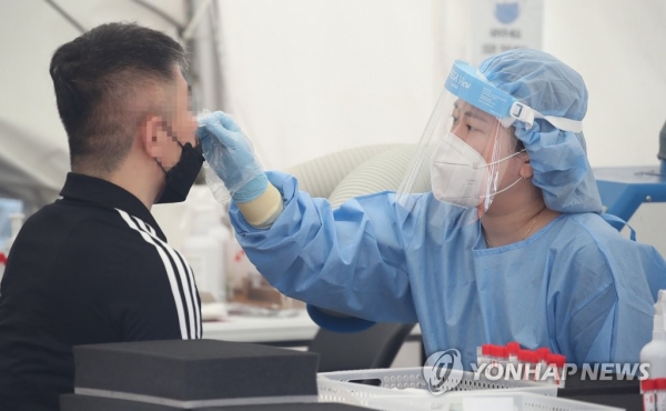 29일 오전 서울 강남구 코엑스 앞에 마련된 신종 코로나바이러스 감염증(코로나19) 임시선별검사소에서 의료진이 검체 검사를 하고 있다.