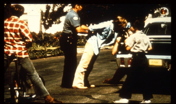 스탠퍼드 감옥 실험에서 스탠퍼드 경찰이 8612번 죄수를 감옥으로 이송하기 전 수갑 채우는 장면 [사진=ATI]
