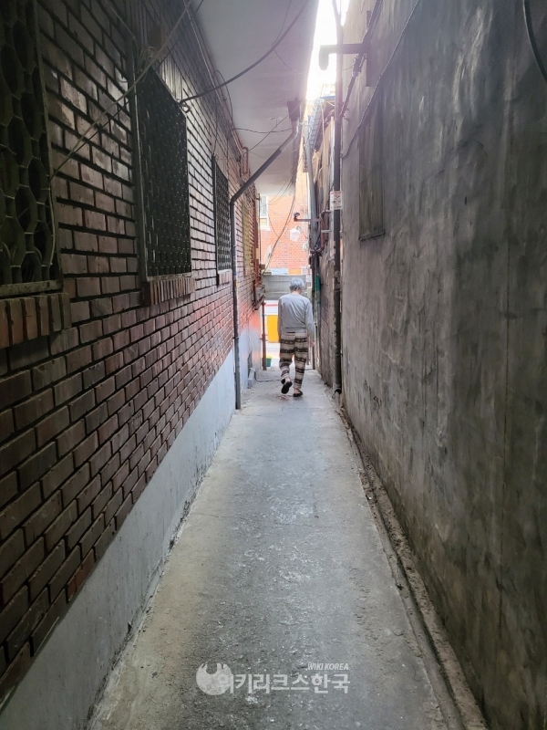 지난 9일 서울 용산구 후암동 거주지에서 만난 문덕수(가명)씨가 쪽방촌에서 외부로 나오는 통로로 걷고 있다. [사진=윤여진 기자]