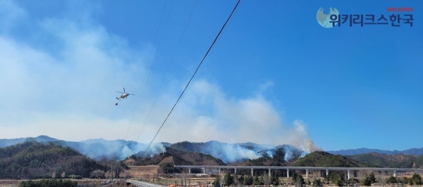경상북도 울진근 북면 일대의 대규모 산불로 인해 화재 진압 헬리콥더가 담수한 물을 가지고 현장으로 이동하고 있다. [출처=위키리크스한국]