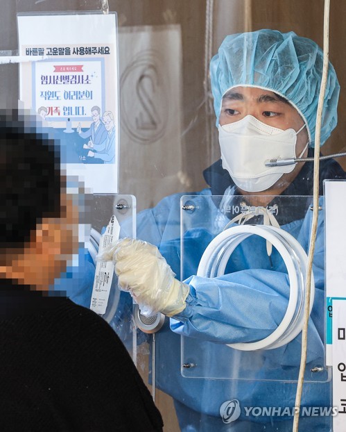 서울 중구 서울역 선별진료소에서 지난 29일 오후 관계자가 PCR 검사를 시행하고 있다.[출처=연합]