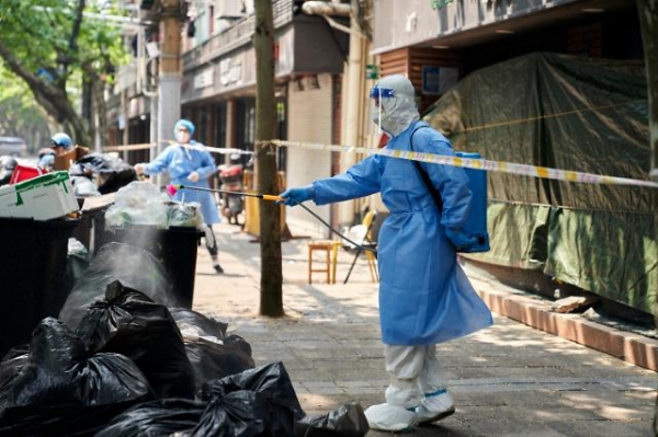 지난 4월 21일, 중국 상하이에서 개인보호장비를 착용한 방역 요원들이 쓰레기봉투 더미를 소독하고 있다. [사진=AP·연합뉴스]