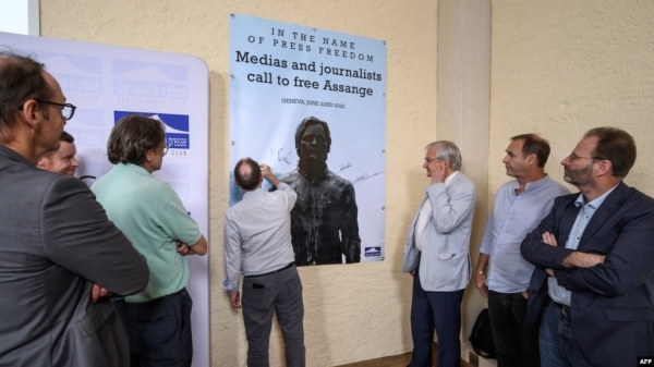 Journalists sign a banner calling to free WikiLeaks founder Julian Assange after a press conference at Geneva press club, in Geneva, June 22, 2022. VOA