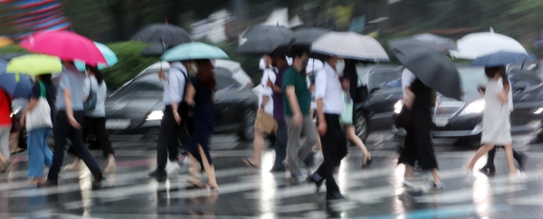 3일 오전 우산을 쓴 시민들이 횡단보도를 걷고 있다. 기상청은 서울 지역 호우 특보를 오전 6시 20분 해제했다. [출처=연합]