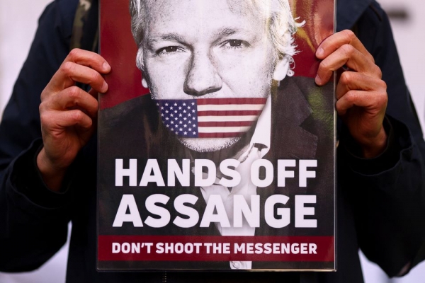A supporter of Julian Assange displays a placard, outside the Westminster Magistrates' Court in London, Britain April 20, 2022. REUTERS=Yonhap
