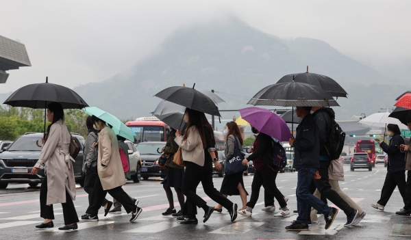 전국 곳곳 비가 예보된 18일 오전 광화문네거리에서 우산을 쓴 시민들이 횡단보도를 건너고 있다. 비는 전국으로 확대된 뒤 오후 들어 그칠 전망이다. 다만 남해안과 제주에서는 내일 낮까지 이어지기도 하겠다. [출처=연합]