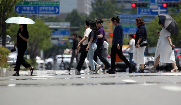 광주 시민들이 뜨거운 햇볕에 달아올라 열기가 피어오르는 도로를 건너고 있다. [사진=연합뉴스]