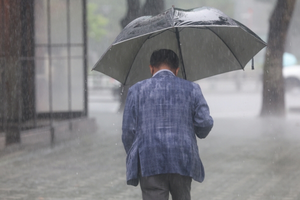 서울 여의도 국제금융로에서 우산을 쓴 시민이 이동하고 있다.[사진=연합뉴스]