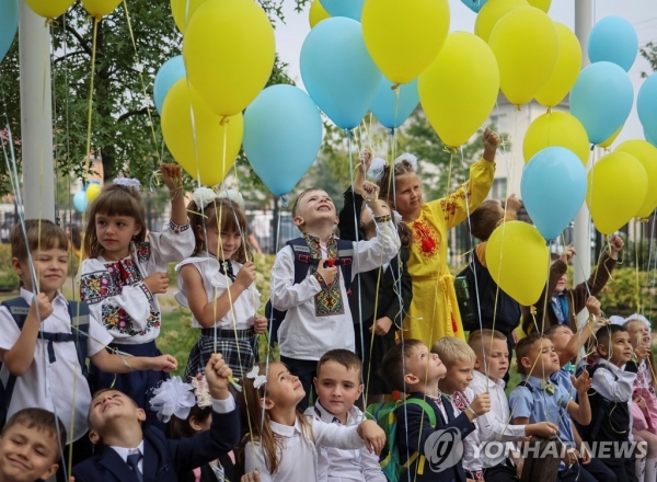 지난해 9월 1일 키이우 외곽 부차에서 신학기 행사에 참여한 우크라이나 학생들: 우크라이나 키이우 외곽 도시 부차의 학교 개학식에서 아이들이 우크라이나 국기 색깔을 상징하는 풍선을 쥐고 있다. [사진 = 연합뉴스]
