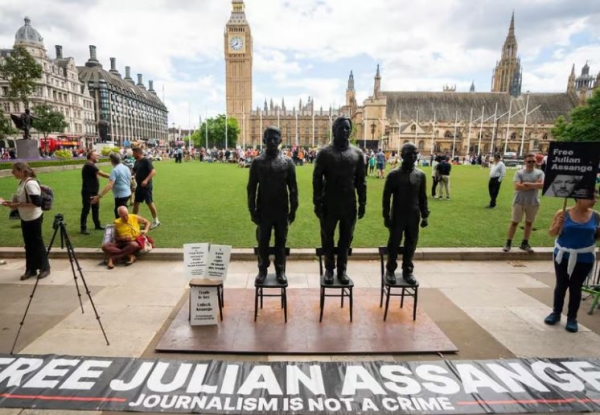 A sculpture called “Anything to Say,” which features life-sized bronze figures of whistleblowers (left-right) Edward Snowden, Julian Assange, and Chelsea Manning, is unveiled at Parliament Square, London, during a protest for Assange’s release from prison. AP=Yonhap
