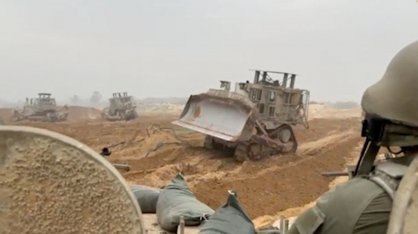 29일(현지시간) 이스라엘군(IDF)이 공개한 가자지구 내 지상 활동 모습. 장갑차량에 탑승한 군인들이 장갑 불도저가 지면을 고르길 기다리고 있다. [출처=이스라엘군/로이터/연합]