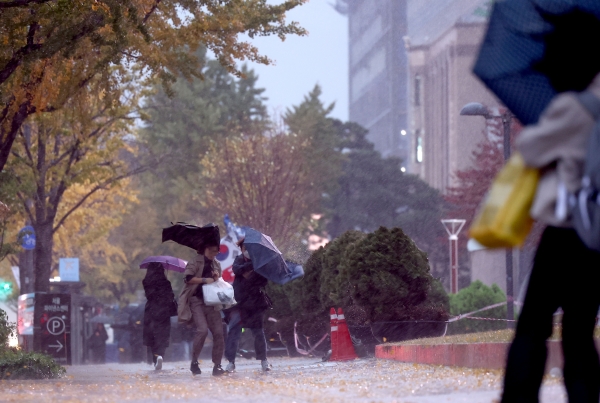 6일 오전 거센 비바람이 부는 서울 시청 인근 세종대로에서 시민들이 강풍을 맞으며 걸어가고 있다. [출처=연합]