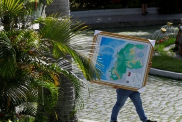(카라카스 로이터=연합뉴스) 6일(현지시간) 베네수엘라 카라카스에서 한 주민이 가이아나 땅까지 자국 영토로 표시된 베네수엘라 '새 지도'를 옮기고 있다.