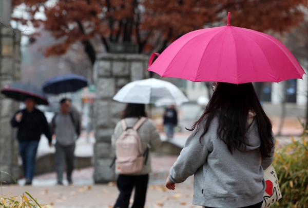 겨울비 내리는 지난 11일 오전 광주 북구 전남대에서 학생들이 우산을 쓰고 횡단보도를 걷고 있다. [출처=연합]