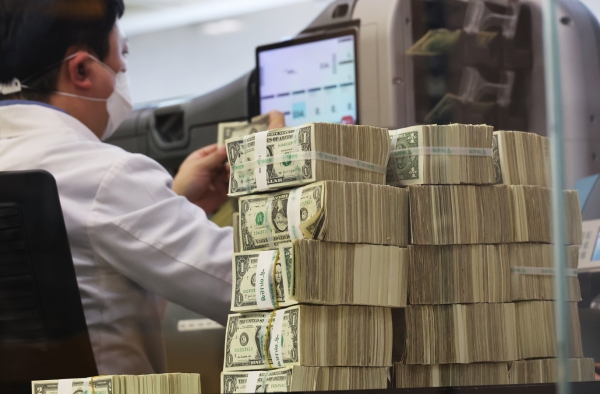 서울 명동 하나은행 본점에서 직원이 미국 달러를 살펴보고 있다. [출처=연합]