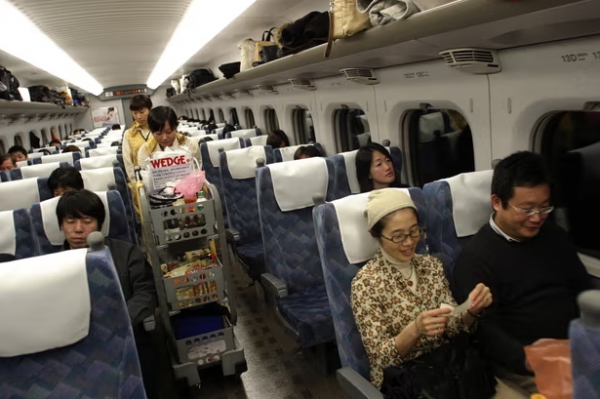 일본 신칸센 고속열차 객실의 음식 판매 카트와 승객들. 도쿄-오사카 노선에서 철수한 카트들이 경매에서 폭발적인 인기를 끌었다. [사진 = 가디언]