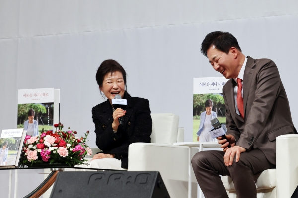 박근혜 전 대통령(왼쪽)이 5일 오후 대구 수성구 인터불고호텔에서 열린 '박근혜 회고록 출간기념 저자와의 대화'에서 유영하 변호사의 발언을 들으며 웃고 있다. [출처=연합]