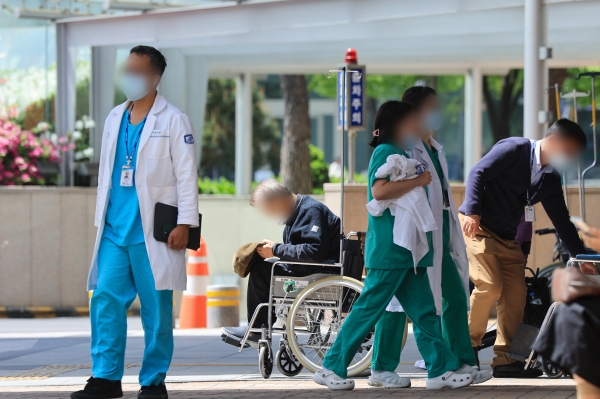 정부의 의대 증원 추진에 반발한 전공의들이 병원을 떠난지 60일째인 18일 서울 시내 한 대학병원에서 의료진이 이동하고 있다. [출처=연합]