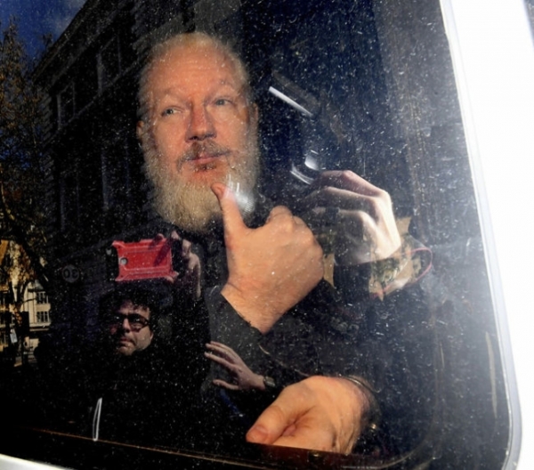 ‘위키리크스’의 창립자인 줄리언 어산지가 11일(현지시각) 영국 런던 에콰도르 대사관에서 경찰에 의해 체포된 뒤 호송차 안에서 엄지손가락을 들어보이고 있다. 런던/AP 연합뉴스