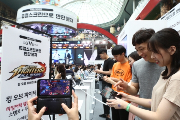 관람객들이 LG V50 ThinQ 와 듀얼 스크린으로 게임을 즐기고 있다. [사진=LG전자 제공]