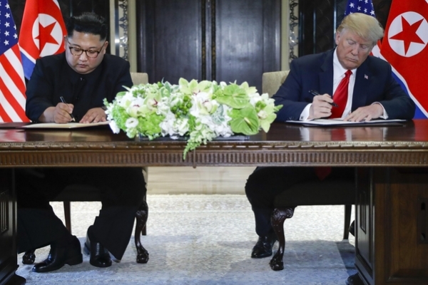 김정은 북한 국무위원장과 도널드 트럼프 미국 대통령이 지난 6월 12일 싱가포르 센토사섬 카펠라호텔에서 싱가포르 선언에 서명하고 있다. 사진=사진공동취재단]