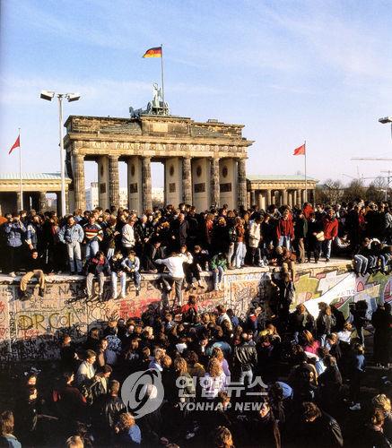 베를린 장벽에 올라가 환호하는 동서독 시민-안드레아스 스프링거의 `베를린 장벽의 붕괴' 사진집 [연합뉴스 자료사진]