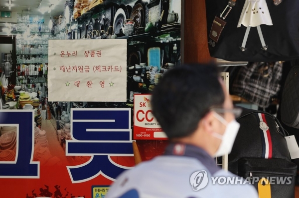 지난달 24일 서울 중구 남대문 시장장의 한 매장에 재난지원금 사용 가능 안내문이 붙었다. [출처=연합뉴스]