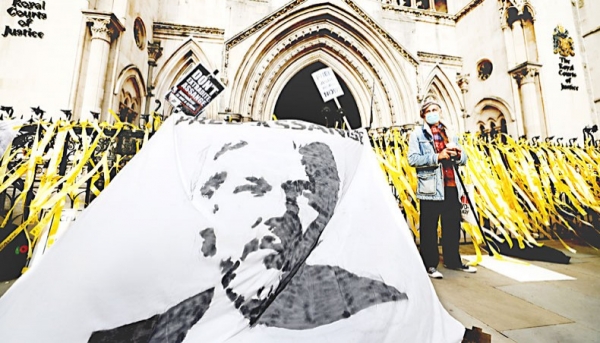 Protesters display a banner with an image of WikiLeaks founder Julian Assange during a demonstration outside the Royal Courts of Justice in London on October 28, the second day of an appeal hearing by the US government against the UK’s refusal to extradite Assange. AFP=YonhapNews