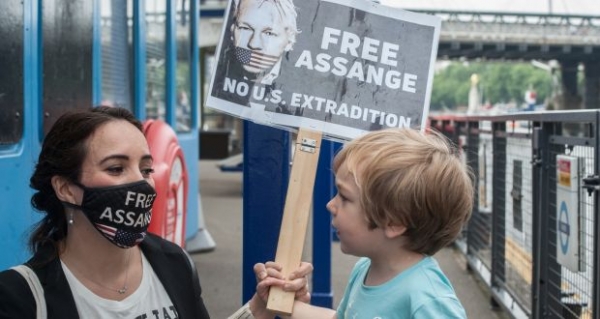 Stella Morris partner of Julian Assange with one of their children at the quay as supporters of Julian Assange hold a protest along the river Thames in 2021./ Source: The Irish Times