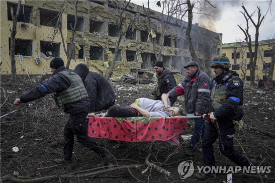 우크라이나 마리우폴 병원의 한 임산부가 폭격 직후 이송되고 있다. 이 임산부와 아이는 사망했다.  [AP=연합뉴스]