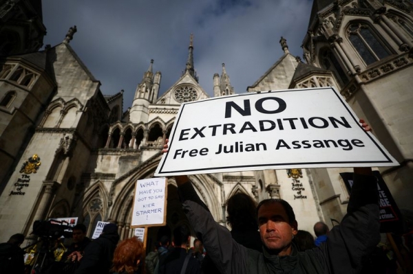 A supporter of WikiLeaks founder Julian Assange held a banner outside the Royal Courts of Justice in London on Wednesday. /REUTERS