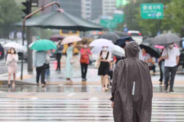 전국 곳곳에 비 소식이 있는 11일 오전 서울 광화문네거리에서 한 시민이 우비를 입은 채 횡단보도를 건너고 있다. [출처=연합]