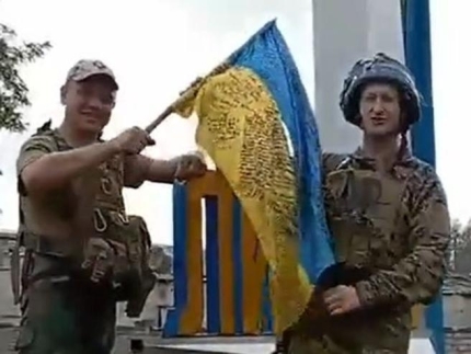 리만 도시 표지판에 국기 꽂는 우크라이나 군인들 [우크라이나 대통령 비서실 제공]