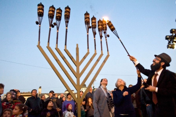 미국 캘리포니아 해변에서 열린 유대인 행사에서 한 랍비가 마노라 촛대에 불을 붙이고 있다. /AP 연합뉴스
