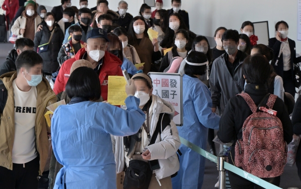 2일 인천국제공항 제1여객터미널 입국장에서 공항 관계자들이 중국발 입국자를 분류하고 있다. 방역당국은 이날부터 중국에서 항공편이나 배편으로 입국하는 모든 사람에 대해 코로나19 유전자증폭(PCR) 검사를 실시하는 등 고강도 방역 대책을 시작했다.[출처=연합]