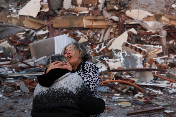 강진 발생 다음날인 7일(현지시간) 지진으로 붕괴한 튀르키예 하타이의 건물 잔해 앞에서 두 사람이 서로 끌어안고 있다. 전날 튀르키예에서 규모 7.8, 7.5의 강진이 잇따라 발생하고 80여 차례 여진이 일어나 튀르키예와 인접국 시리아에서 지금까지 4천명 이상이 사망했다. 여진은 이날 오전에도 발생했다. [출처=연합]