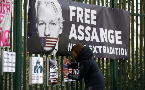 A supporter of WikiLeaks founder Julian Assange posts a sign outside a court ahead of a hearing to decide whether Assange should be extradited to the US, in London, the UK, February 25 2020. /REUTERS = Yonhap