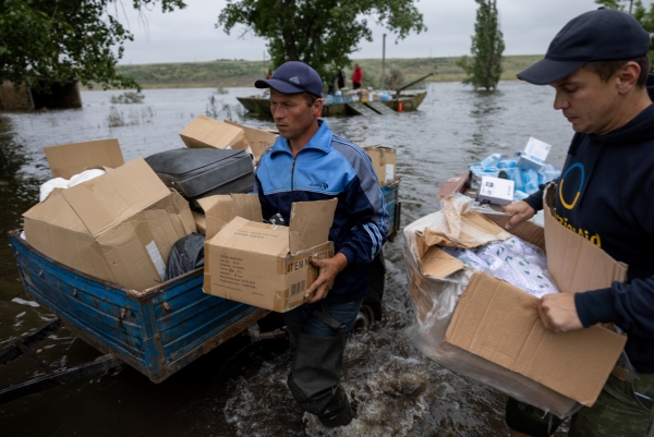 ) 자원봉사자들이 12일(현지시간) 우크라이나 카호우카 댐 파괴로 침수된 남부 미콜라이우주(州) 아파나시이우카 마을에 구호물자를 전달하고 있다. 지난 6일 헤르손주의 카호우카 댐이 무너지면서 드니프로강 하류 마을 일대가 홍수에 잠겼다. 우크라이나는 러시아가 댐을 공격했다고 주장하고 있다. [출처=연합]
