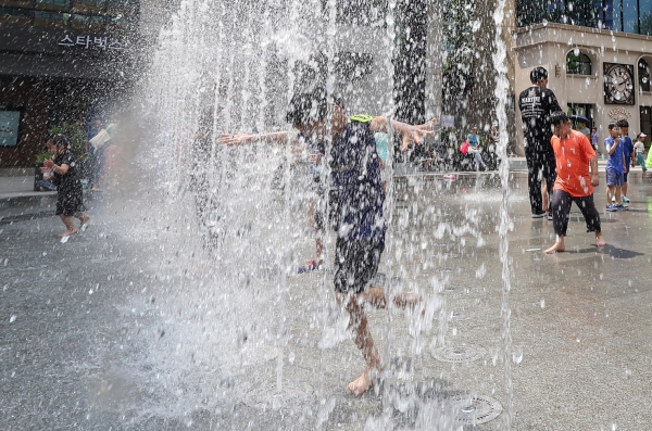 서울 종로구 광화문광장 분수대에서 어린이들이 물놀이를 즐기고 있다. [출처=연합]